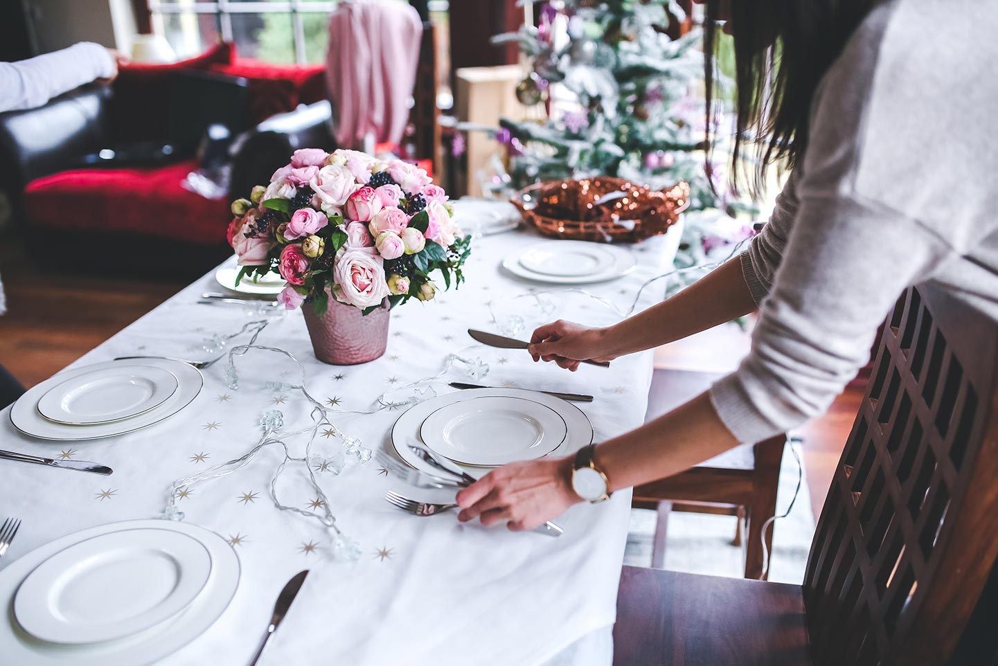 A waitress sets and elegant table for dinner